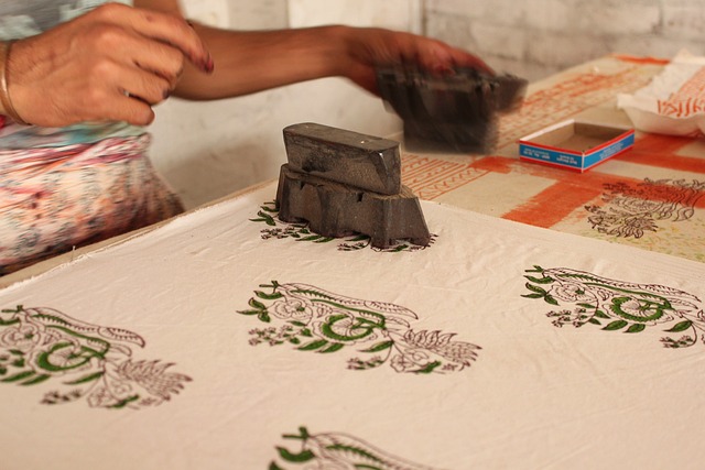 an artisan performing the traditional Indian block printing on fabric