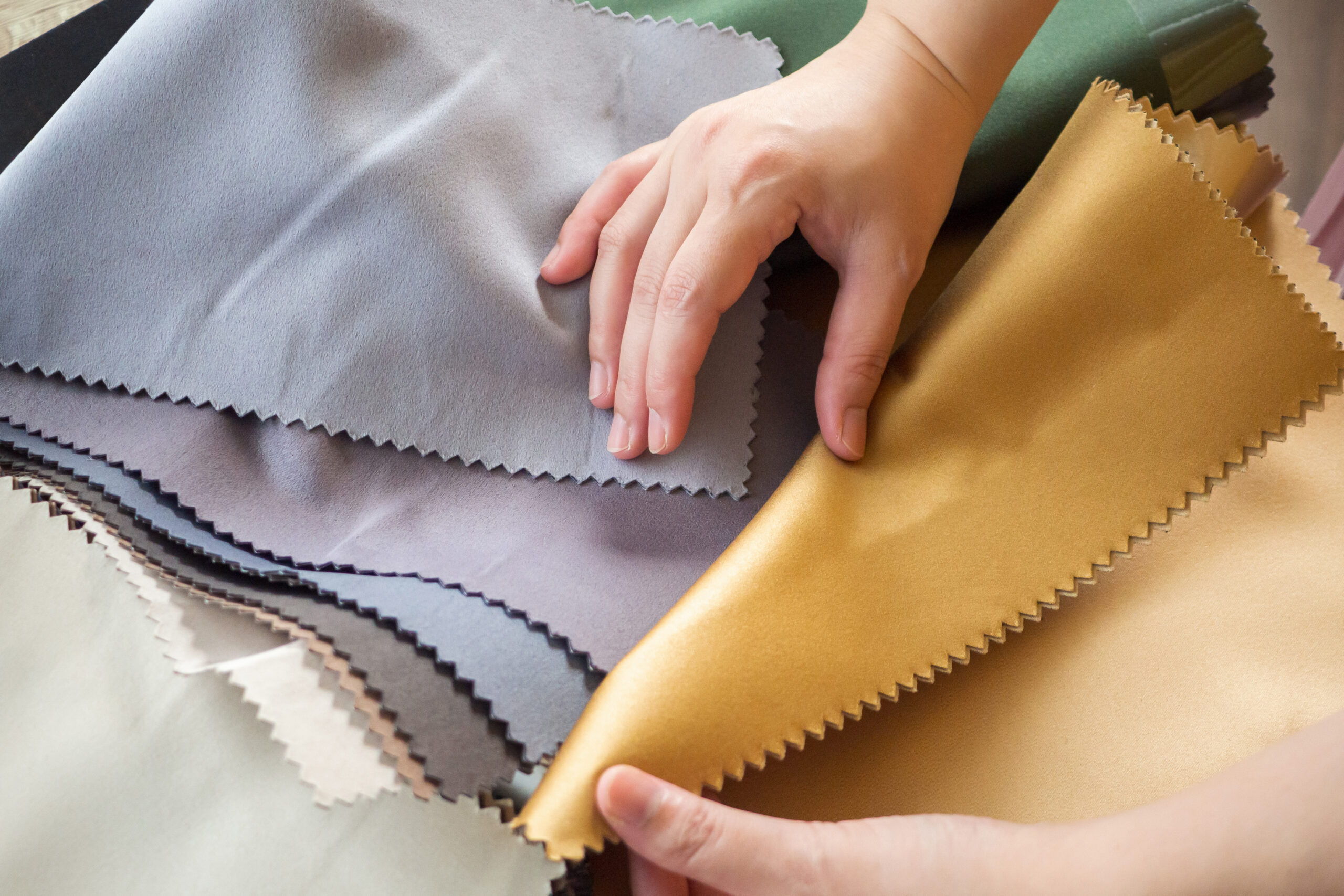 female designer with fabric color samples choosing textile for garmets