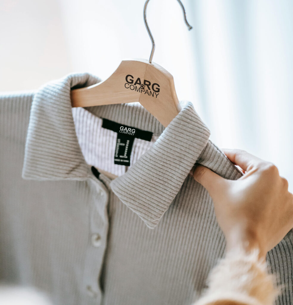 a shirt hung in a hanger being looked at by a person